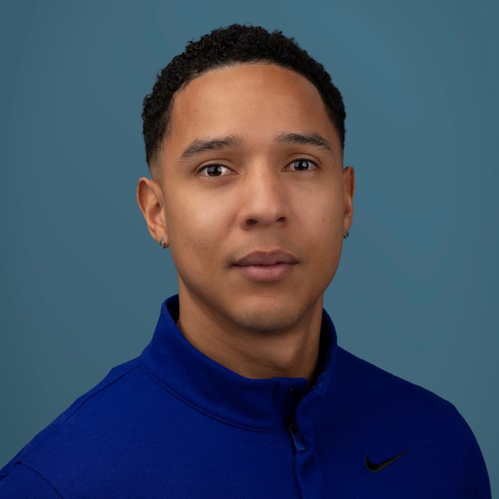 Fascial Stretch Therapist, Ali Placid headshot in front of blue wall